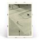 Cyclist on an empty street at dawn captured in artwork 7 AM New Years Morning by László Moholy-Nagy Poster of a black and white city street scene with a cyclist by László Moholy-Nagy titled 7 A.M. New Year’s Morning