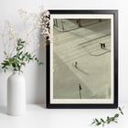Cyclist on an empty street at dawn captured in artwork 7 AM New Years Morning by László Moholy-Nagy Poster of a black and white city street scene with a cyclist by László Moholy-Nagy titled 7 A.M. New Year’s Morning