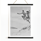 Acrobatic jump at the beach by Tivoli stars Acrobatics at the Beach Poster of Acrobatics at the Beach by Two Tivoli Stars featuring two people in swimsuits jumping on a sandy beach.