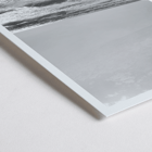 Surfer with a board by the ocean in a black and white picture titled Surfer in Portugal by artist Black Black and white poster Surfer in Portugal by Black & White Picture depicts a lone surfer entering the ocean carrying a surfboard.