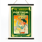 Colorful vintage poster of a woman carrying grapes by William Fox titled Portugal Today Poster of Portugal Today by Anonymous featuring a woman in traditional attire carrying fruit on her head with colorful backdrop