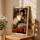 The Clothed Maja exhibition poster by Francisco Goya featuring a reclining woman in a white dress with yellow sleeves The Clothed Maja exhibition poster by Francisco Goya at Fondation Beyeler featuring the reclining woman in white and gold attire