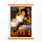 The Clothed Maja exhibition poster by Francisco Goya featuring a reclining woman in a white dress with yellow sleeves The Clothed Maja exhibition poster by Francisco Goya at Fondation Beyeler featuring the reclining woman in white and gold attire