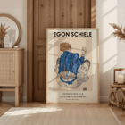 Egon Schiele exhibition poster featuring Woman Seated Back artwork Poster of Woman Seated Back artwork by Egon Schiele showing a woman with a colorful garment sitting with her back turned
