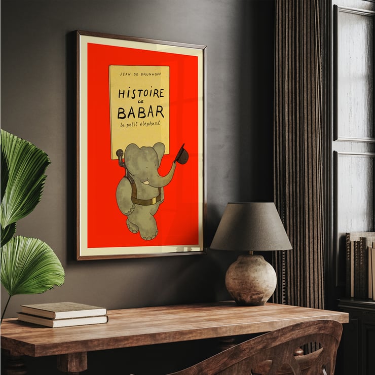 Illustration of a cheerful elephant carrying a hat from Histoire de Babar by Jean de Brunhoff. Poster of an elephant holding a hat by Jean de Brunhoff titled Histoire de Babar on a red background.