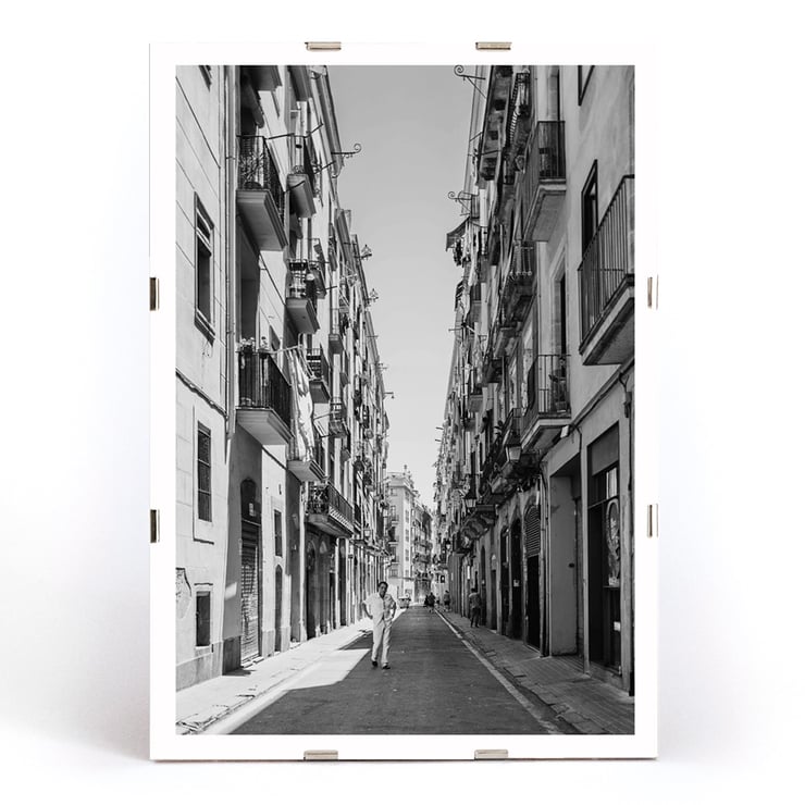 Schwarzweißfotografie von Street of Barcelona, die einen Mann zeigt, der eine schmale Stadtstraße entlanggeht. Schwarzweißposter mit der Abbildung einer schmalen Straße in Barcelona mit dem Titel „Straße von Barcelona“ und einer Person in der Mitte.