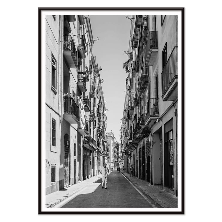 Schwarzweißfotografie von Street of Barcelona, die einen Mann zeigt, der eine schmale Stadtstraße entlanggeht. Schwarzweißposter mit der Abbildung einer schmalen Straße in Barcelona mit dem Titel „Straße von Barcelona“ und einer Person in der Mitte.