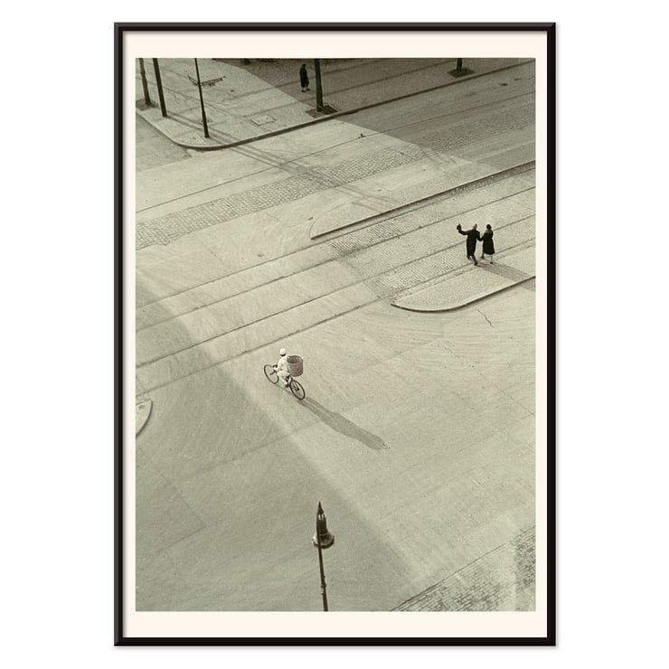 Cyclist on an empty street at dawn captured in artwork 7 AM New Years Morning by László Moholy-Nagy Poster of a black and white city street scene with a cyclist by László Moholy-Nagy titled 7 A.M. New Year’s Morning