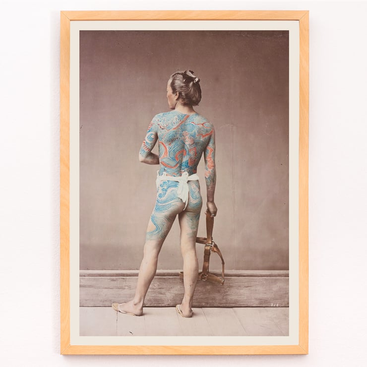Japanese Tattoo Art by Raimund von Stillfried featuring intricate body art on a person standing with a tool. Poster of a man with intricate tattoos covering his back and arms holding a tool titled Japanese Tattoo by Raimund von Stillfried