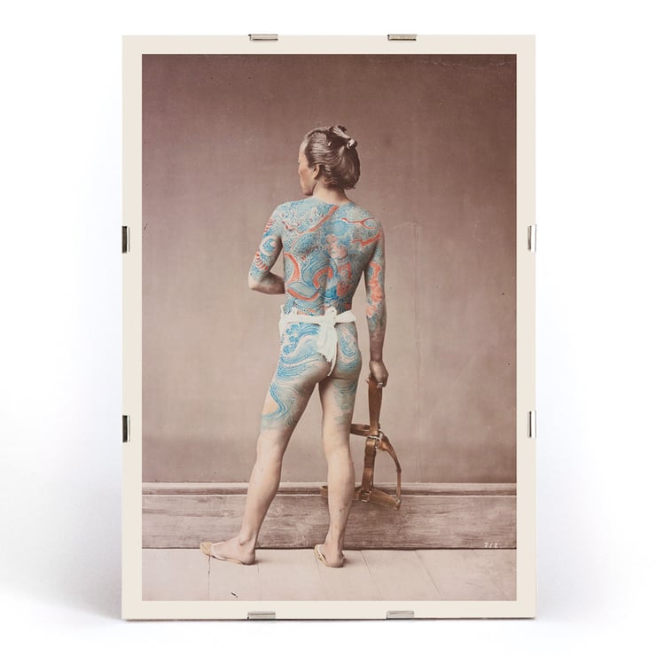 Japanese Tattoo Art by Raimund von Stillfried featuring intricate body art on a person standing with a tool. Poster of a man with intricate tattoos covering his back and arms holding a tool titled Japanese Tattoo by Raimund von Stillfried