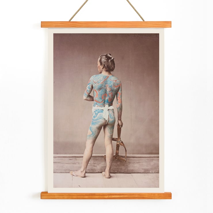 Japanese Tattoo Art by Raimund von Stillfried featuring intricate body art on a person standing with a tool. Poster of a man with intricate tattoos covering his back and arms holding a tool titled Japanese Tattoo by Raimund von Stillfried