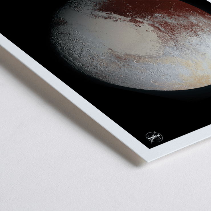 Image of Pluto by NASA in a black frame. Poster featuring Pluto with detailed surface textures displayed by NASA titled Pluto by NASA.