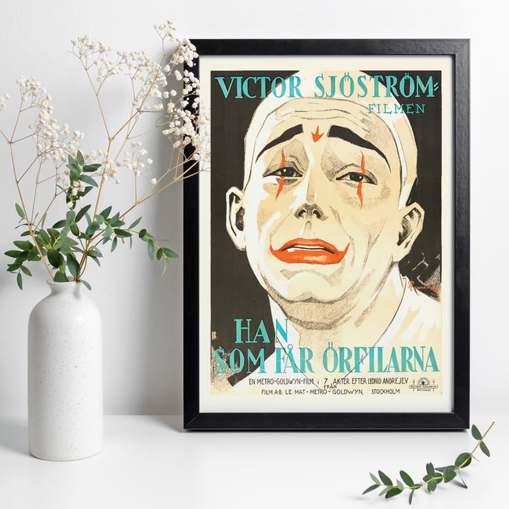 Vintage movie poster of He Who Gets Slapped by Eric Rohman featuring a clown face with red makeup. Poster of He Who Gets Slapped by Eric Rohman featuring a sad clown face with dramatic makeup and bold text in Swedish.
