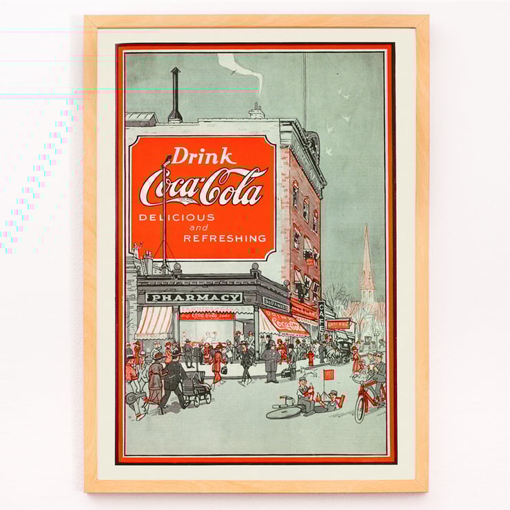 Drink Coca Cola vintage advertisement depicting a busy street scene Poster titled Drink Coca Cola showing a bustling street scene with people near a pharmacy and a large Coca Cola billboard