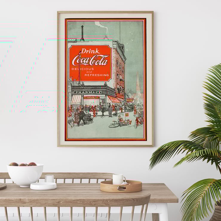 Drink Coca Cola vintage advertisement depicting a busy street scene Poster titled Drink Coca Cola showing a bustling street scene with people near a pharmacy and a large Coca Cola billboard