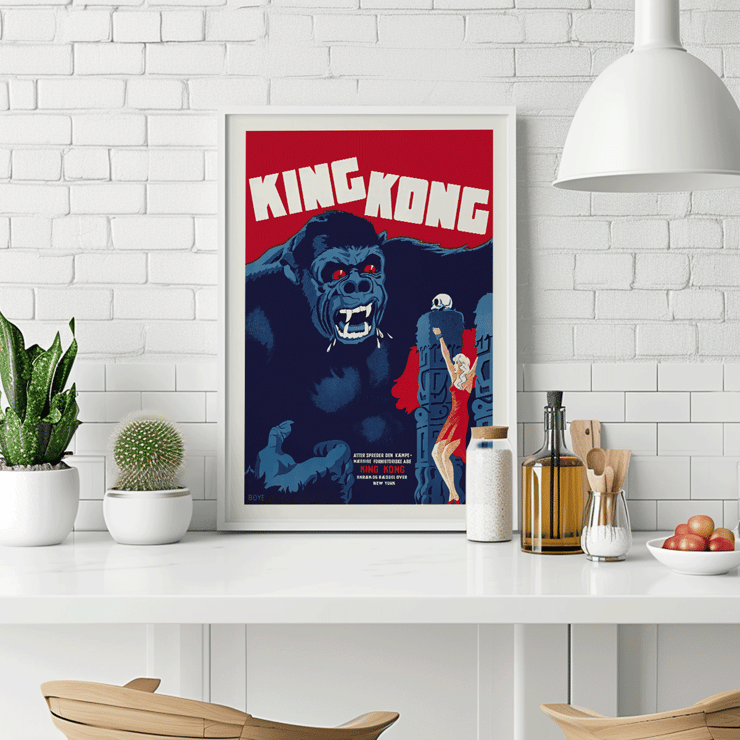Póster de la película King Kong de Boye que presenta una escena icónica con un mono gigante y una mujer. Afiche de la película King Kong de Boye que muestra a un gorila gigante con ojos rojos agarrando un edificio con una mujer con un vestido rojo levantando su mano.