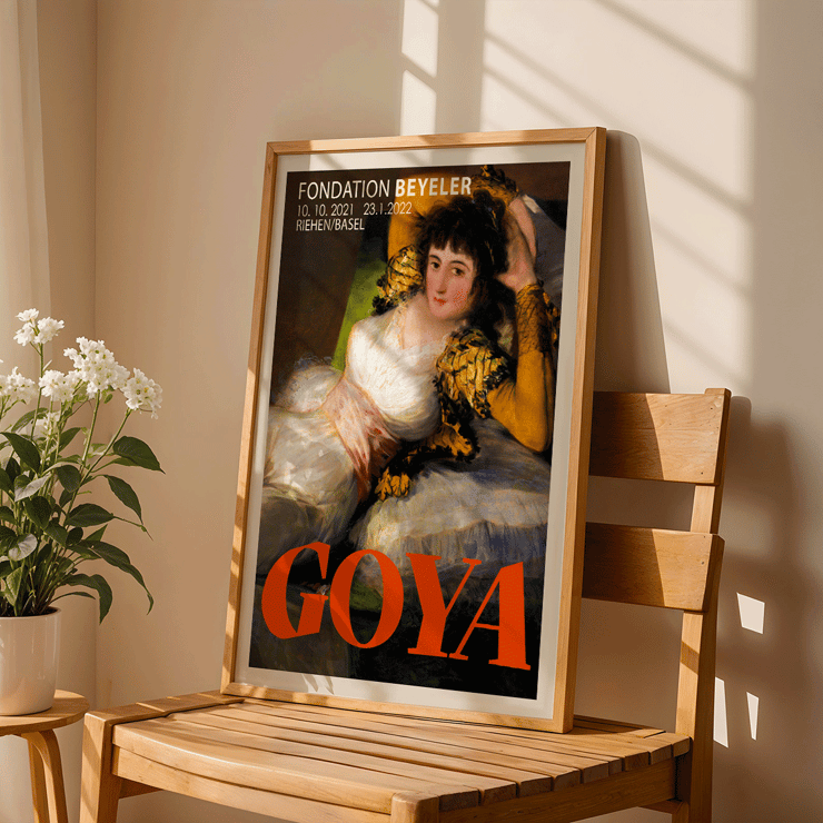 The Clothed Maja exhibition poster by Francisco Goya featuring a reclining woman in a white dress with yellow sleeves The Clothed Maja exhibition poster by Francisco Goya at Fondation Beyeler featuring the reclining woman in white and gold attire