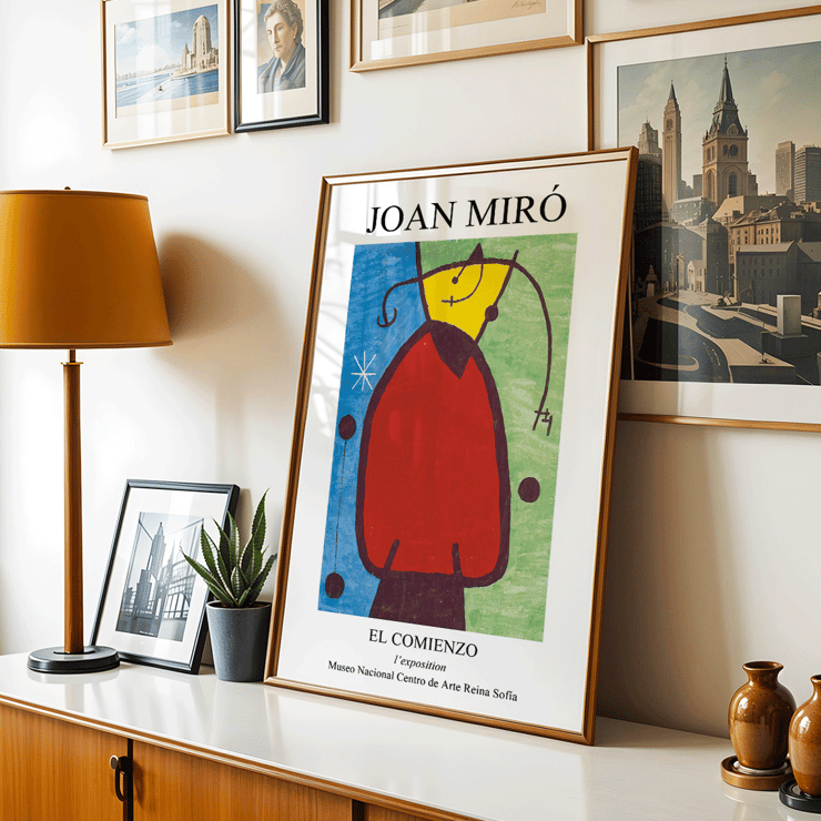Exhibition poster featuring El Comienzo by Joan Miro with colorful abstract design. El Comienzo exhibition poster inspired by Joan Miro featuring abstract shapes and vibrant colors in a framed display