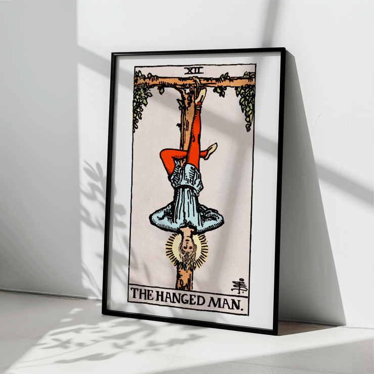 The Hanged Man tarot card by Rider Waite featuring a figure suspended upside-down from a wooden post. Poster depicting Tarot - The Hanged Man by Rider Waite showing a man hanging upside down by one leg from a wooden structure