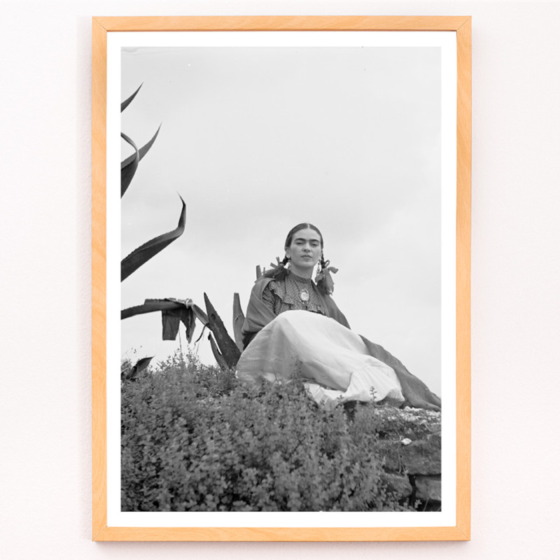 Frida Kahlo sentada ao lado de uma planta de agave