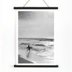 Black and white poster Surfer in Portugal by Black & White Picture depicts a lone surfer entering the ocean carrying a surfboard.