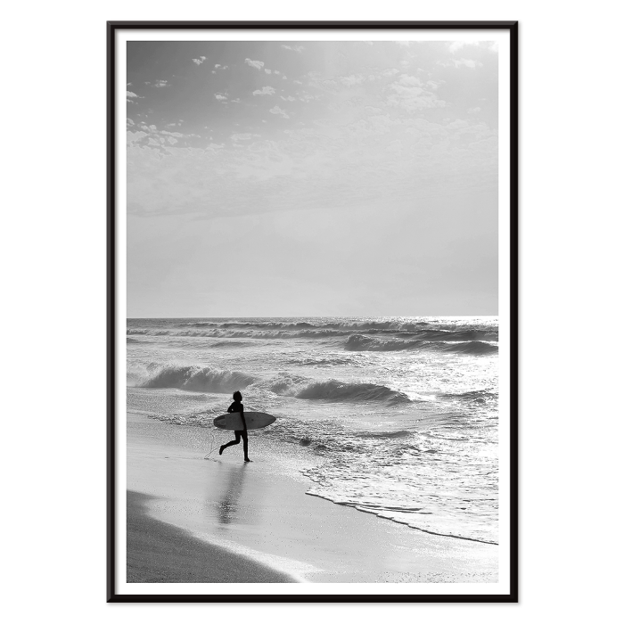 L'affiche noir et blanc Surfer in Portugal de Black & White Picture représente un surfeur solitaire entrant dans l'océan portant une planche de surf.