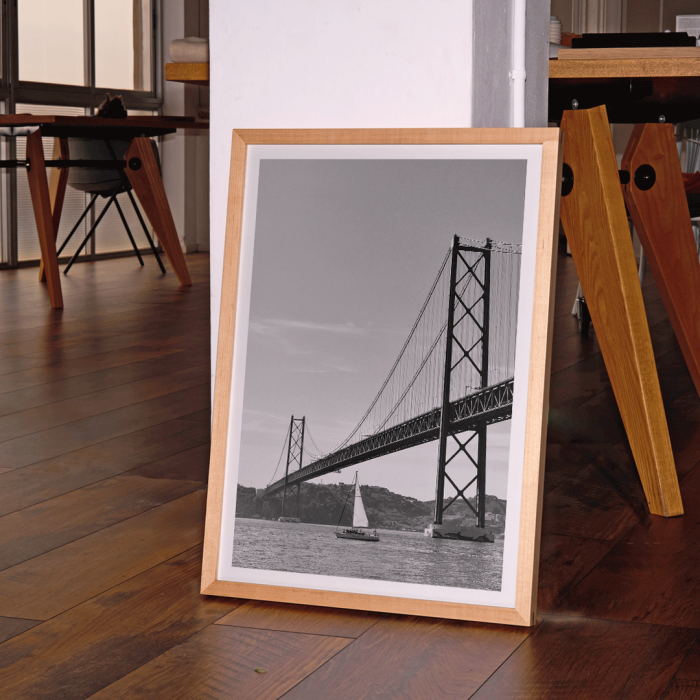 Poster featuring Lisbon Bridge Black & White Picture with a framed photograph of a suspension bridge and a sailboat in the water