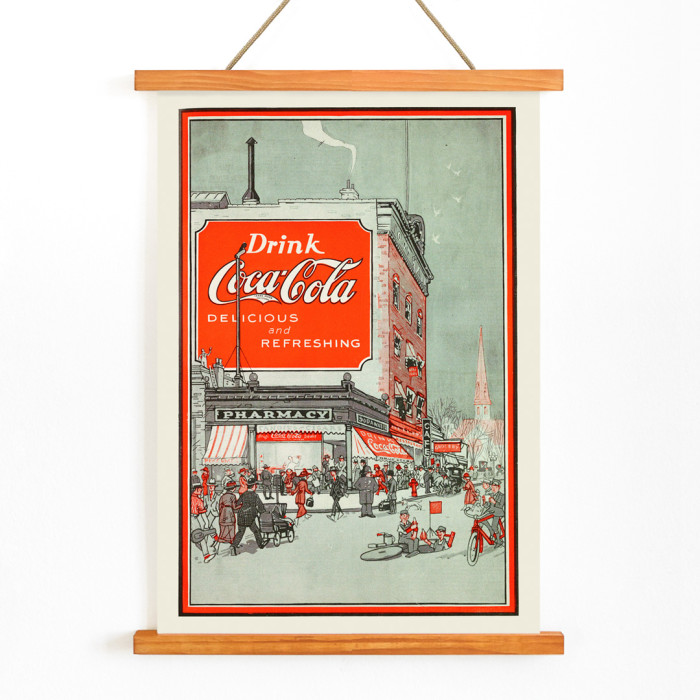 Poster intitulé Drink Coca Cola montrant une scène de rue animée avec des gens près d'une pharmacie et un grand panneau d'affichage Coca Cola