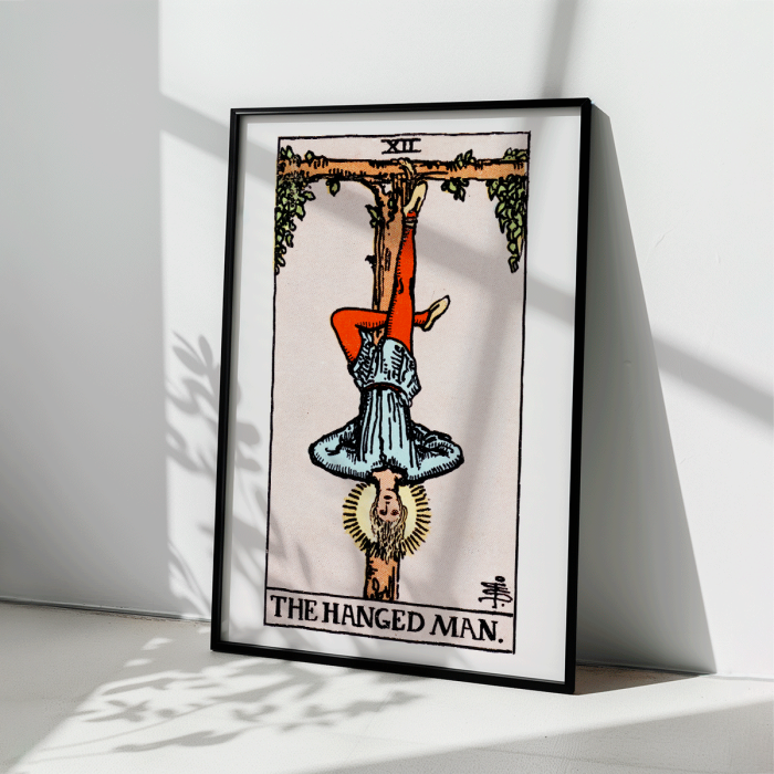 Poster depicting Tarot - The Hanged Man by Rider Waite showing a man hanging upside down by one leg from a wooden structure